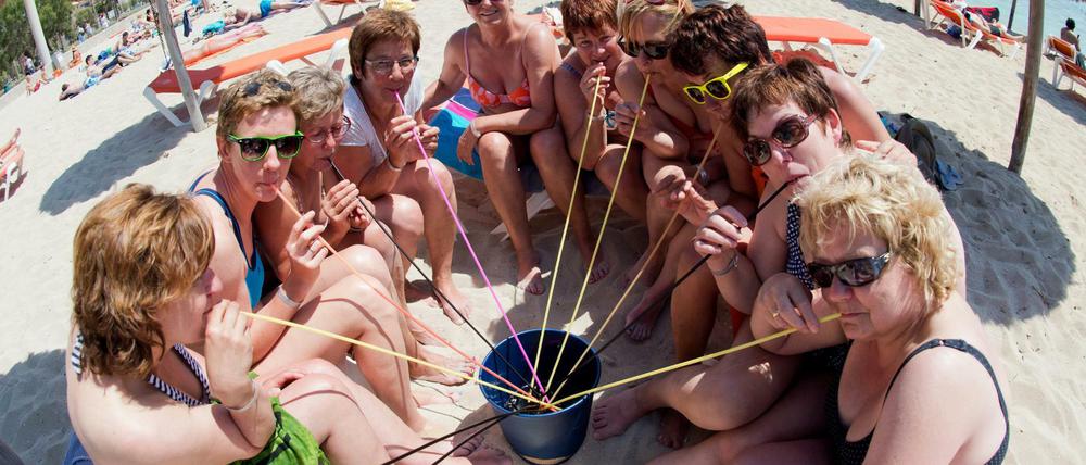 Eine Frauengruppe aus Neumünster trinkt aus einem Eimer am Strand von Arenal auf der Mittelmeerinsel Mallorca (Spanien). "Saufgelage" sind hier bald wieder verboten. 