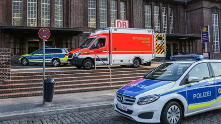 Rettungskräfte und Polizisten stehen vor dem Bahnhof in Flensburg. 
