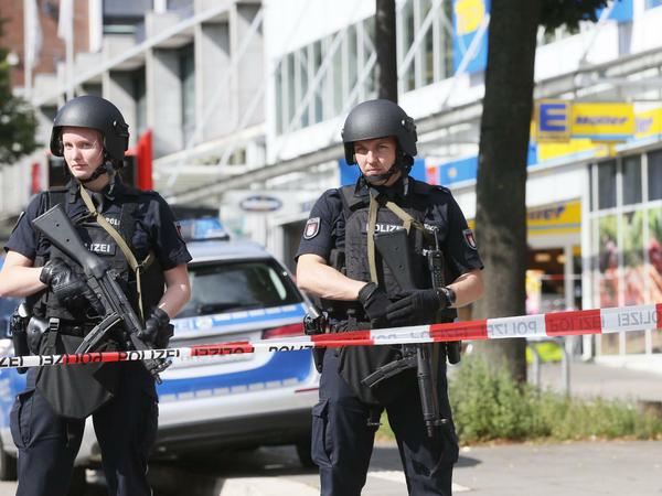 Einsatzkräfte der Polizei sperren am Freitag nach einer Messerattacke in einem Supermarkt in Hamburg den Tatort ab. 