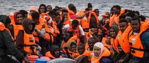Flüchtlinge und Migranten warten auf einem überfüllten Schlauchboot darauf, gerettet zu werden (Symbolbild). 