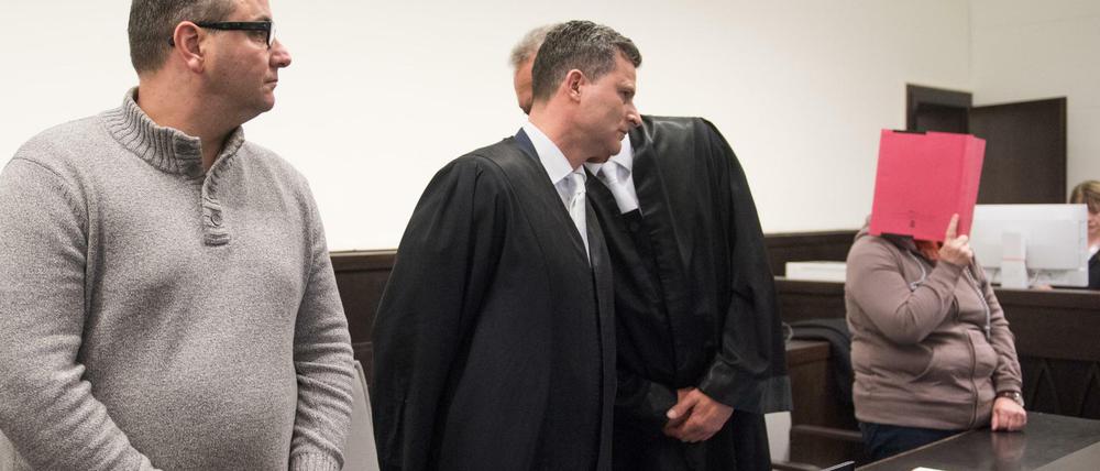 Die Angeklagten Wilfried W.(l) und Angelika W. (r, mit Aktenordner vor dem Gesicht) stehen in Paderborn vor Gericht. 