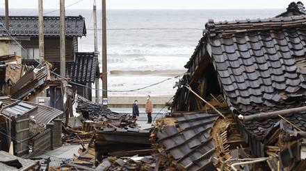 Menschen blicken zurück auf die eingestürzten Häuser in der Präfektur Ishikawa.