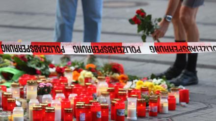 Nach der Messerattacke in Würzburg werden Blumen vor einem abgesperrten Kaufhaus niedergelegt.