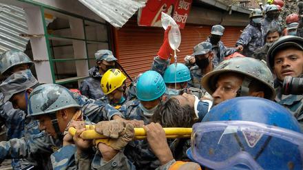 Rettungskräfte in Nepal tragen einen 18-Jährigen auf einer Bahre, der fünf Tage in den Trümmern überlebt hatte. 