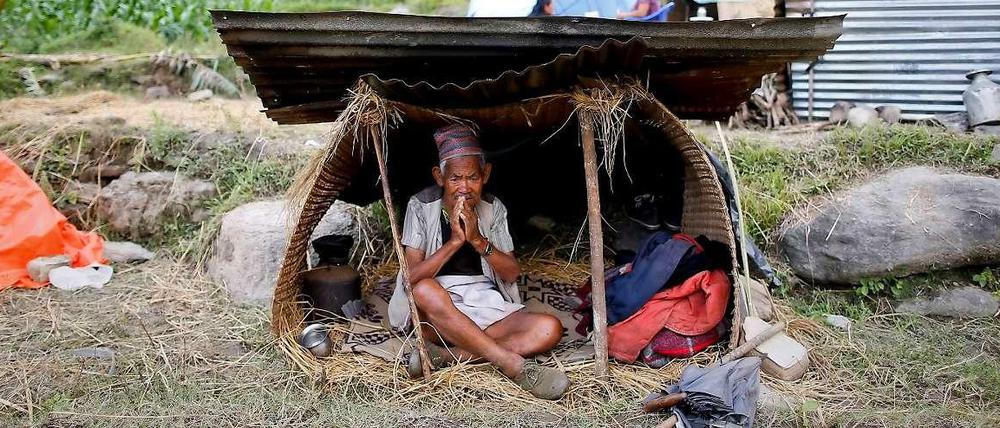 Ein Nepalese sitzt in einer selbsgebastelten Unterkunft, nachdem er sein Haus durch das große Erdbeben verloren hatte.