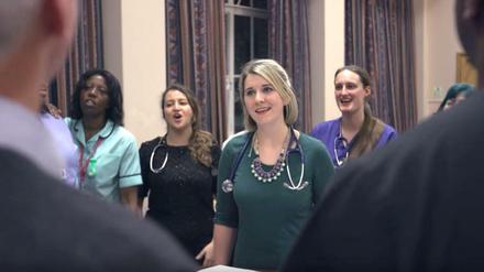 Ärzte, Schwestern und weiteres Krankenhaus-Personal bilden den NHS-Chor.