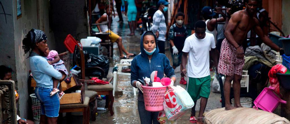 Menschen in Santa Domingo sichern nach Tropensturm „Laura“ ihre Habseligkeiten 