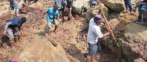 Menschen, die nach einem Erdrutsch im Dorf Yambali in der Region Maip Mulitaka in der Provinz Enga in Papua-Neuguinea graben.