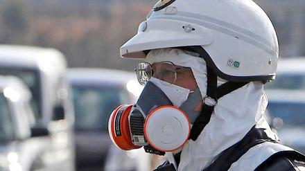 Ein Polizist mit Atemschutzgerät bei der Evakuierung des Gebietes rund um das Atomkraftwerk Fukushima.