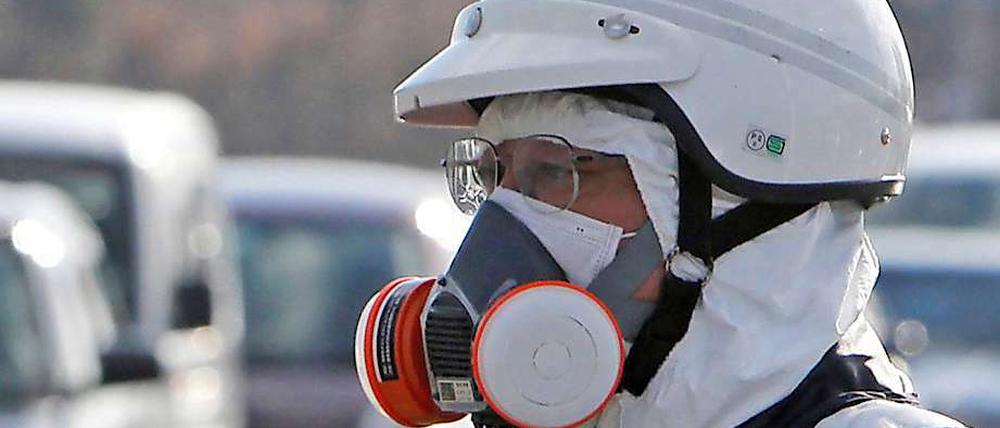 Ein Polizist mit Atemschutzgerät bei der Evakuierung des Gebietes rund um das Atomkraftwerk Fukushima.