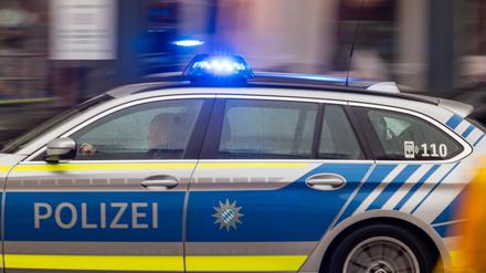 Ein Polizeiwagen fährt mit Blaulicht durch München.