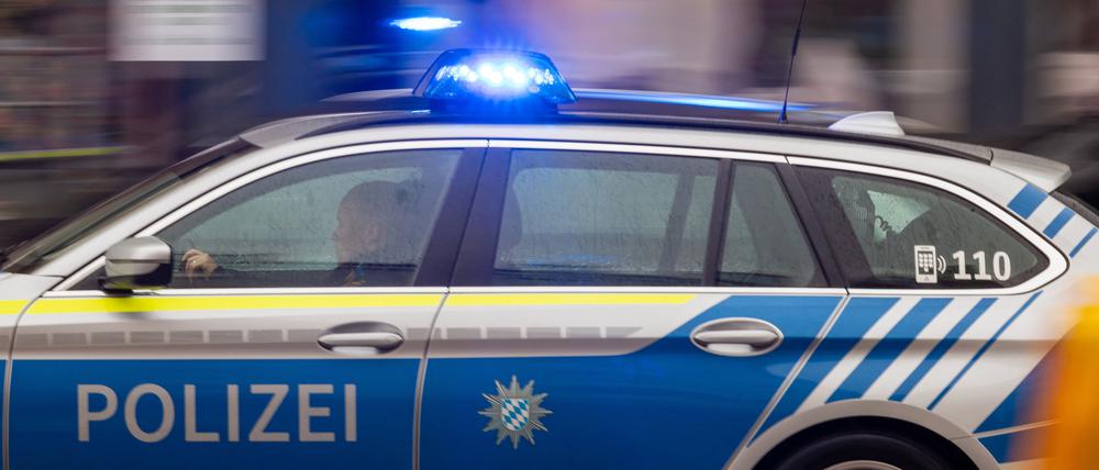 Ein Polizeiwagen fährt mit Blaulicht durch München.