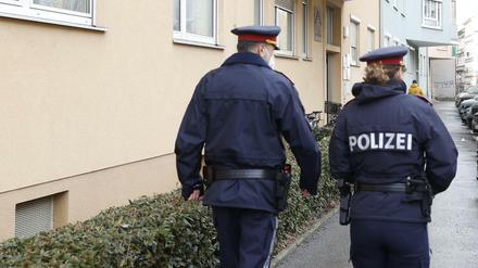 Österreichische Polizeibeamte vor einem Mehrfamilienhauses