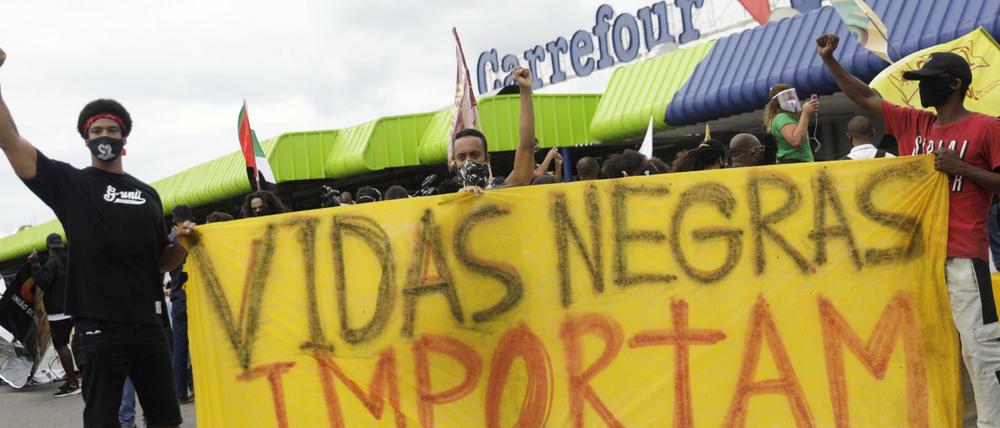 Demonstranten halten vor einem Carrefour-Supermarkt ein Banner mit der Aufschrift „Schwarze Leben zählen“ hoch.