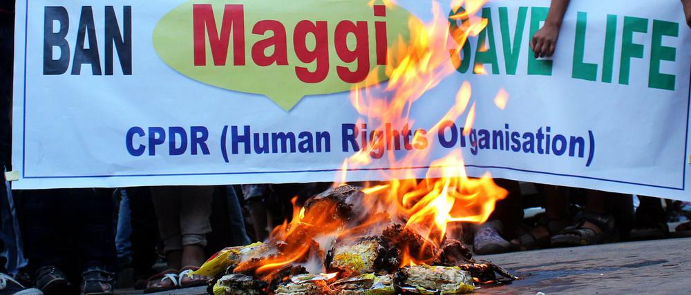 Studenten und Aktivisten in Indien verbrennen aus Protest Nudel-Packungen. "Ban Maggi - Save Life" (Verbannt Maggi - rettet Leben) steht auf dem Banner. 