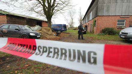 Spezialisten der Polizei untersuchen am 19.11.2014 hinter einer Polizeiabsperrung im Dorf Haale (Schleswig-Holstein) einen Brandort.