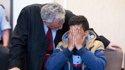 Der angeklagte Algerier sitzt am 06.05.2016 im Amtsgericht in Köln neben seinem Verteidiger Rüdiger Buhr auf der Anklagebank und hält sich die Hand vor das Gesicht. Der 23-Jährige muss sich wegen Raubes und versuchten Diebstahls verantworten. Sein Bruder ist wegen versuchter sexueller Nötigung angeklagt. 