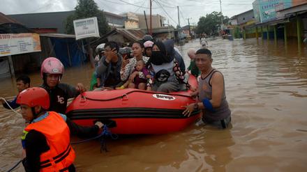 Mit Booten werden Bewohner der Insel Sulawesi aus ihren überschwemmten Häusern gerettet.