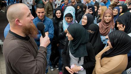 Der radikale Salafistenprediger Pierre Vogel (l) spricht bei einer Kundgebung in Offenbach am Main (Hessen).