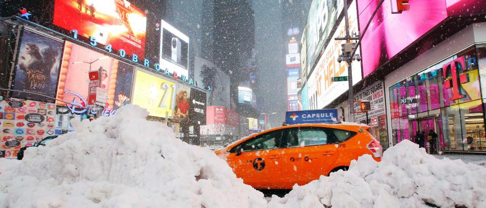 Ein Taxifahrer passiert auf dem Times Square in New York einen Schneehaufen. 