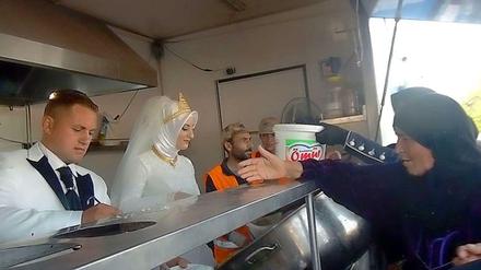 Ein Brautpaar aus der Türkei verteilt Essen an Flüchtlinge aus Syrien in Kilis. 
