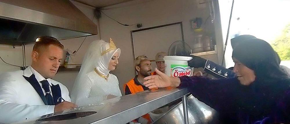 Ein Brautpaar aus der Türkei verteilt Essen an Flüchtlinge aus Syrien in Kilis. 