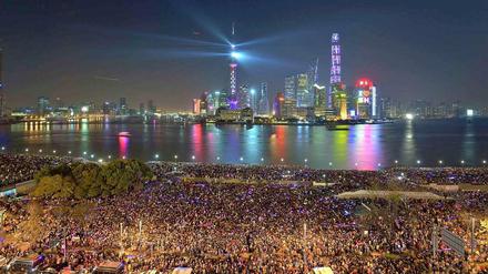 Zehntausende Menschen versammelten sich an der Hafenbauer von Shanghai und blickten auf die Silhouette von Pudong.