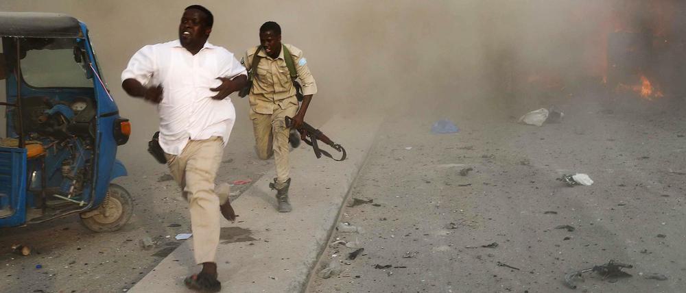 Sicherheitskräfte fliehen vor der Explosion in Mogadishu.