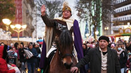 Ein Darsteller des St. Martin reitet auf einem Pferd durch die Duisburger Innenstadt.