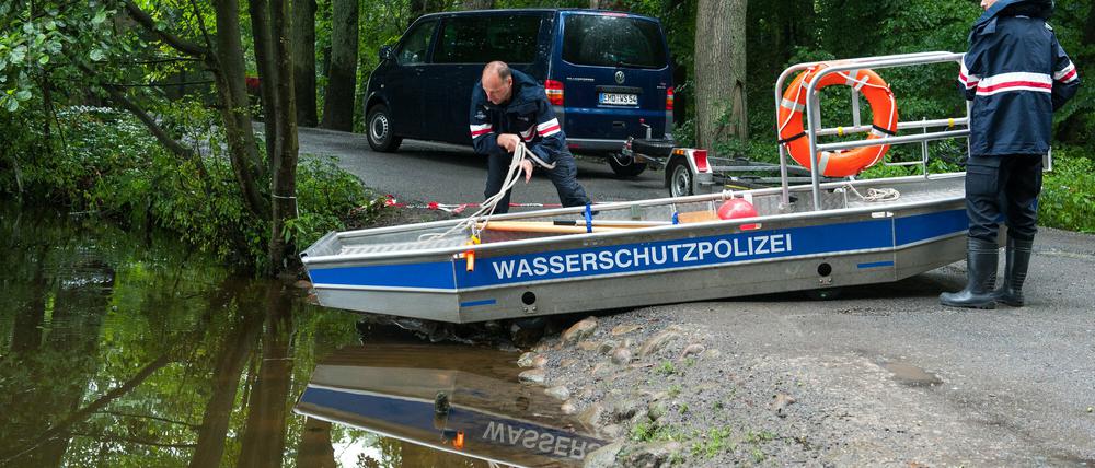 Einsatzkräfte der Polizei bereiten ein Boot mit einem Sonargerät am 19.08.2015 bei Holm-Seppensen bei nahe Buchholz in der Nordheide (Niedersachsen) für die Suche nach einer vermissten Mutter und ihrer Tochter vor. Am Freitag gab die Polizei bekannt: die Suche war ergebnislos. 