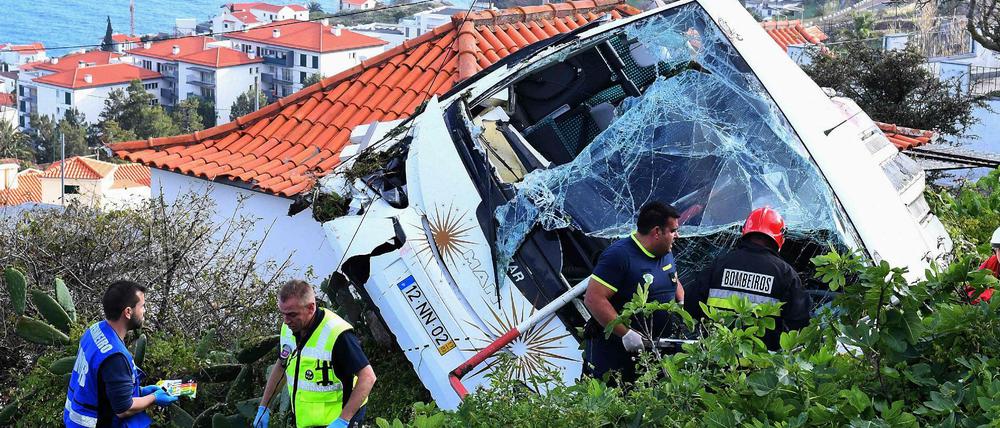 Rettungskräfte am Wrack des abgestürzten Busses in der Gemeinde Caniço.
