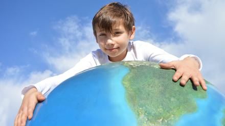Weltkindertag 2018: Ein Junge mit einem Globus