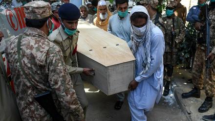 Soldaten und Angehörige tragen Opfer des Flugzeugabsturz in Karachi zu Grabe.