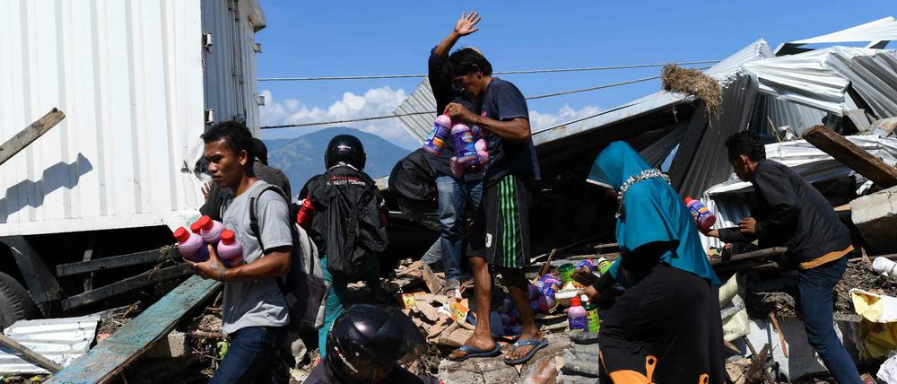 Menschen sichern noch nutzbare Dinge aus den Trümmern eines Hauses im indonesischen Palu.