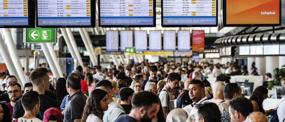 Lauter Verspätungen und Annulierungen – und unter den Tafeln ratlose Passagiere am Amsterdamer Flughafen.