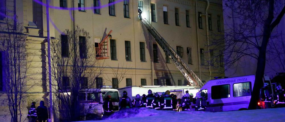 Ein Feuerwehrmann steigt durch ein Fenster eines Universitätsgebäudes in St. Petersburg. 