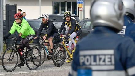 Hobbyfahrer sind unter Polizeibegleitung auf der Strecke des abgesagten Frankfurter Radrennens unterwegs. 
