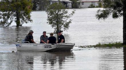 Bewohner fahren mit einem Boot durch überflutete Teile der australischen Stadt Lawrence.