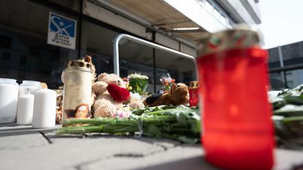 Blumen, Kerzen, Stofftiere und Bilder liegen vor dem Hochhaus, in dem am Mittwoch, den 11. Mai, zwei Kinder getötet wurden.
