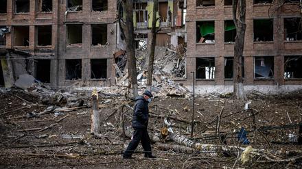 Nach einem russischen Raketenangriff im Februar schlendert ein Mann durch einen Kiewer Vorort.