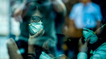 TOPSHOT - Passengers walk while wearing protective masks, as a preventive measure regarding the COVID-19 virus, at Jorge Chavez International Airport, in Lima on February 27, 2020. - So far, Peru has no record of the COVID-19 virus cases. (Photo by Ernesto BENAVIDES / AFP)