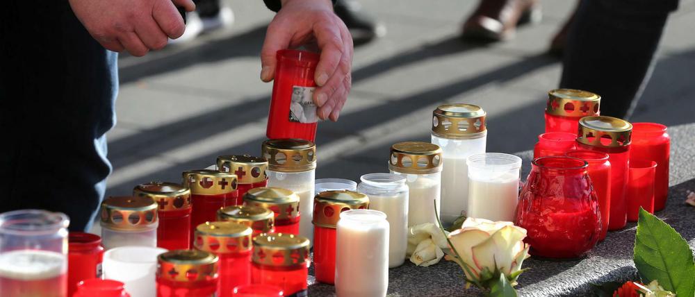 Ein Mann platziert ein Grablicht an einem Rondell am Königsplatz. Ein Feuerwehrmann war am Freitagabend (06.12.2019) hier so schwer verletzt worden, dass er noch vor Ort starb.