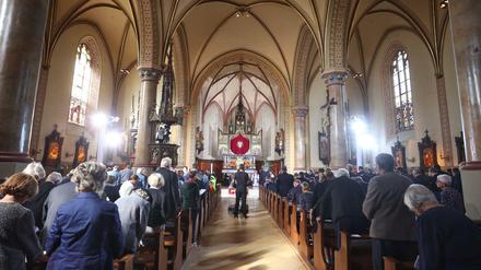Besucher stehen bei einem Trauergottesdienst für die Opfer des Zugunglücks in der Pfarrkirche Maria Himmelfahrt.