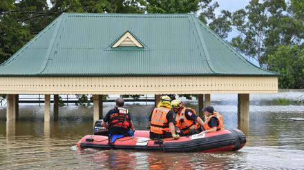 Freiwillige des State Emergency Service (SES) fahren mit einem Rettungsboot durch überflutete Teile von Camden im Südwesten Sydneys.