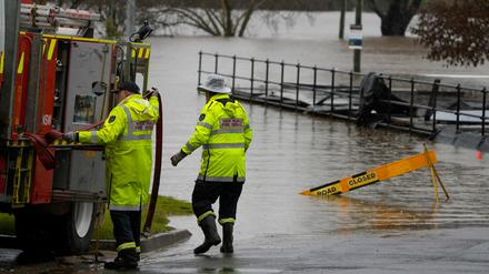 Mitglieder der örtlichen Feuerwehr arbeiten an einer überfluteten Sportstätte in Camden am Stadtrand von Sydney.