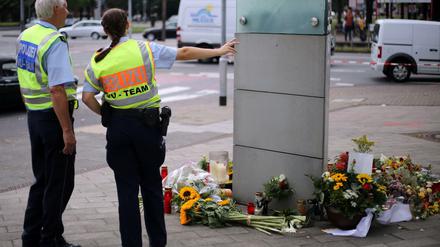 Polizisten stehen am Mittwoch in Köln an einer Unfallstelle, an der Blumen und Kerzen liegen. Bei einem illegalen Autorennen an der Stelle ist am Freitag ein Radfhrer möglicherweise angefahren worden.