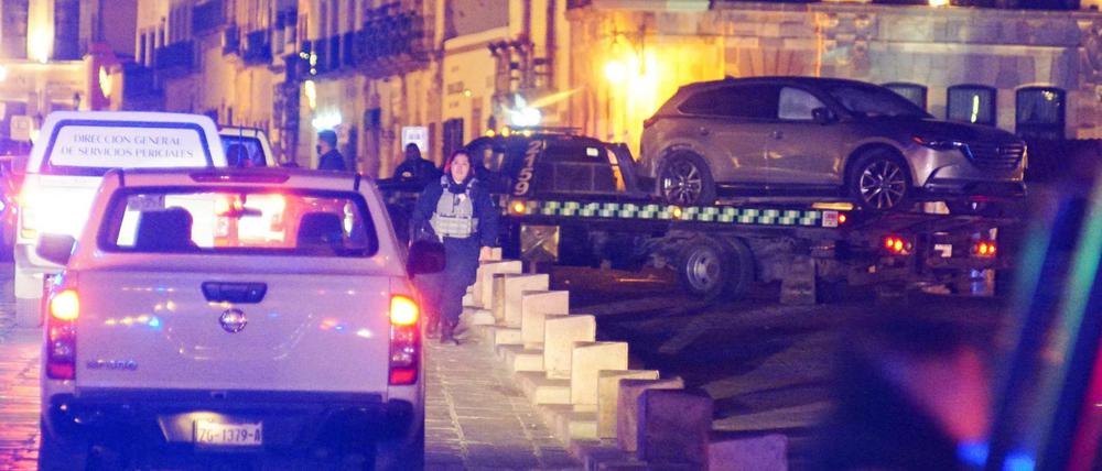 Polizeikräfte entfernen ein Fahrzeug mit Leichen, das Unbekannte vor dem Regierungspalast in Zacatecas zurückließen.