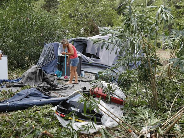 Eine Frau packt die Reste der zerstörten Zelte und anderen Gegenstände auf dem korsischen Campingplatz Sagone ein.