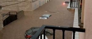 Autos stehen auf einer überfluteten Straße im Wasser.