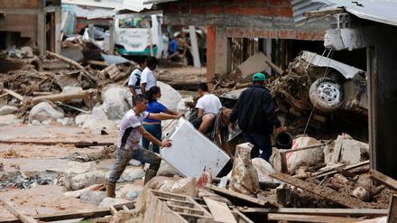 Von einer Unwetterkatastrophe betroffene Menschen suchen in Moncoa (Kolumbien) nach persönlichen Gegenständen.